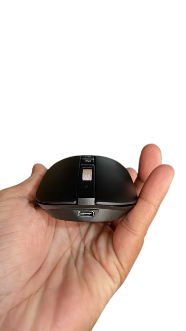 Black computer mouse held in a hand against a white background